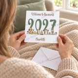 Personalised 2027 woodland new baby card held in hands, featuring squirrel, owl, hedgehog and bunny design