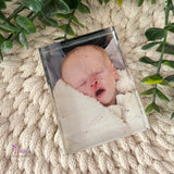 Personalised portrait crystal photo block displayed at an angle on a soft knitted background