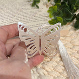 Silver butterfly bookmark with white tassel shown in natural light, plated stainless steel memorial gift.