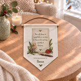 Personalised Christmas robin remembrance pennant with Nanna personalisation, displayed on a wooden table in a festive setting.