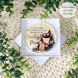 Acrylic memorial bauble in the “Empty Chair” design personalised with Steve, shown inside a white gift box with greenery around the display.