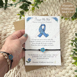 Forget me not remembrance wish bracelet held in hand on seed card