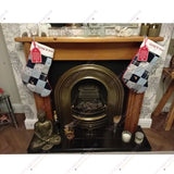 Pair of handmade memory patchwork Christmas stockings hanging on fireplace, crafted from loved ones’ clothing as unique keepsake decorations.
