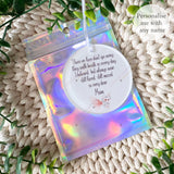 Personalised pink butterfly remembrance bauble shown inside holographic gift pouch – acrylic memorial ornament with “Those we love don’t go away” quote.