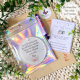 Flat lay of personalised pink butterfly remembrance bauble with holographic packaging, thank-you card, and sweet treat – remembrance gift from Loveable Keepsakes UK.