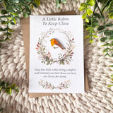 Robin remembrance enamel pin badge displayed on an A6 keepsake poem card with a recycled brown envelope, cream knitted background and greenery.