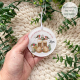 Hand holding a personalised acrylic robin remembrance bauble featuring two robins perched above winter boots, with the words “Robins appear when loved ones are near” and a custom name – memorial keepsake decoration.