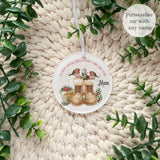 Personalised robin remembrance bauble shown in a holographic gift pouch – printed with robins, winter boots, and floral design, a thoughtful acrylic memorial ornament for loved ones.
