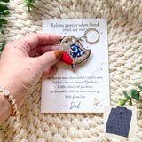 Hand holding robin memorial keyring on personalised card, remembrance keepsake.
