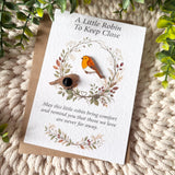 Robin enamel pin badge shown from the front and reverse, including its secure black rubber clutch fastening, beside the A6 remembrance poem card.