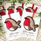 Group of handmade felt robin decorations displayed on remembrance cards with the quote “Robins appear when loved ones are near.