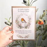 Gift-ready robin remembrance enamel pin and A6 keepsake poem card with a recycled brown envelope and clear protective sleeve.
