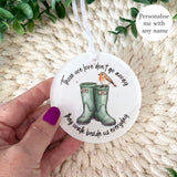 Hand holding robin remembrance boots bauble with personalised names Mum and Dad