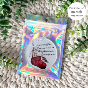 Hand holding a personalised robin remembrance Christmas stocking bauble with “Mum” on the tag