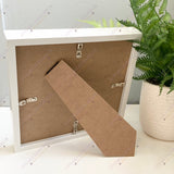 Back of box frame showing stand and hanging fixture for versatile home display.