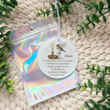 "Mam robin bauble displayed beside holographic gift pouch"