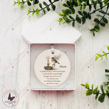 Personalised robin and candle memorial bauble with angel wings, shown inside a white gift box with the name Mum.