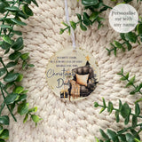 Empty Chair Christmas bauble personalised with the name Dad, featuring armchair, Christmas tree and robin artwork. Acrylic remembrance ornament shown on knitted background.