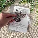 Guardian Angel Bookmark with butterfly design on a card held by a hand, with greenery in the background.