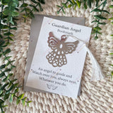 Guardian Angel Bookmark with butterfly design on a textured surface with green leaves.