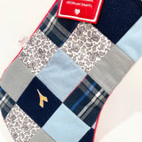 Detailed close-up of patchwork squares on handmade memory Christmas stocking, showing mix of fabrics and quality stitching.