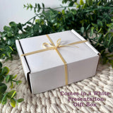 White presentation gift box tied with gold ribbon for a personalised crystal photo block