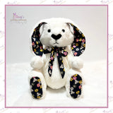 Front view of a white jointed memory bunny with floral inner ears, foot pads and matching neck bow.