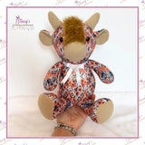 Small Memory Highland Cow keepsake handmade from loved one's clothing, shown being held to demonstrate its smaller size
